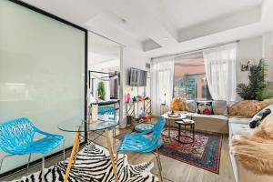 een woonkamer met een glazen tafel en blauwe stoelen bij Central Boston Bliss Family Haven Awaits in Boston