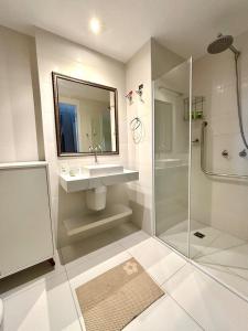 a white bathroom with a sink and a shower at Flat Mirant Vila Madalena in São Paulo