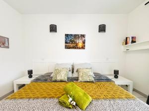 a bedroom with a large bed with a yellow blanket at Bleu Lagon - Vue mer, Piscine, Marina et Golf in Saint-François