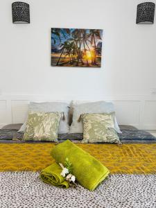 a bed with a green blanket and flowers on it at Bleu Lagon - Vue mer, Piscine, Marina et Golf in Saint-François +13 photos