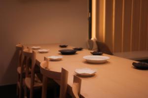 a wooden table with bowls and chairs around it at 富士山望むプライベートヴィラ 900平方メートルの敷地を貸切利用 憩 ikoi Fuji サウナ 4Kシアター in Fujikawaguchiko