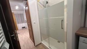 a glass shower in a bathroom with a hallway at Studio - Proche Centrex & Disneyland in Noisy-le-Grand