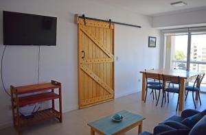 een woonkamer met een schuifdeur en een tafel bij Franca Austral in Puerto Madryn