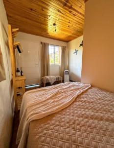 a bedroom with a large bed in a room at Dormís La Cabaña in San Antonio de Areco