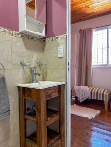 a bathroom with a sink in a room at Dormís La Cabaña in San Antonio de Areco