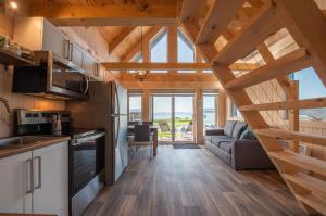 eine Küche und ein Wohnzimmer in einer Blockhütte in der Unterkunft Chalets Nautika Gaspésie in Gaspé