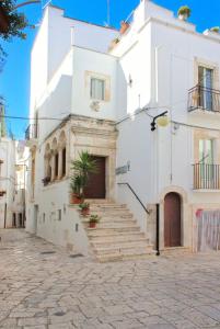 un edificio bianco con scale in una strada di Casa Bruni 104 a Putignano