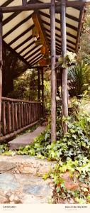 a wooden structure with a bunch of plants under it at Cabaña en La Calera con Jacuzzi in La Calera