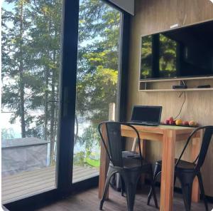 a desk with a laptop on it in a room with a window at Cabaña sobre Playa Lago Gutierrez 1 in San Carlos de Bariloche