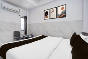 巴特那Hotel O Diamond Tree的卧室配有白色的床,墙上有3张照片