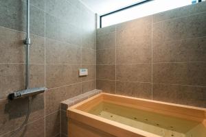 a bathroom with a tub and a glass shower at 富士山望むプライベートヴィラ 900平方メートルの敷地を貸切利用 憩 ikoi Fuji サウナ 4Kシアター in Fujikawaguchiko
