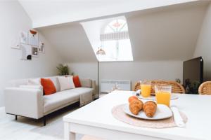 a living room with a table with a plate of croissants at 2 Bed Apartment, Fast Wifi, Free Parking, Near Train Station, Close to Hospitals in Stockport