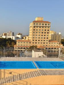 a swimming pool with a building in the background at Hotel Caribe Plaza Barranquilla in Barranquilla