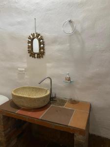 a bathroom with a stone sink and a mirror at Casa Hotel Villa Ronda in Barichara