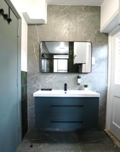 a bathroom with a blue sink and a mirror at Crown Terrace Apartment in London