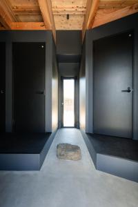 a room with two doors and a rock on the floor at 富士山望むプライベートヴィラ 900平方メートルの敷地を貸切利用 憩 ikoi Fuji サウナ 4Kシアター in Fujikawaguchiko