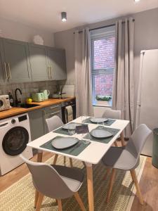 a kitchen with a white table and chairs in a kitchen at Crown Terrace Apartment in London