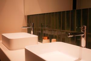 a bathroom with a white sink and a green wall at 富士山望むプライベートヴィラ 900平方メートルの敷地を貸切利用 憩 ikoi Fuji サウナ 4Kシアター in Fujikawaguchiko