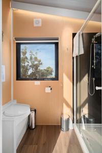 Un baño con inodoro y ventana. en Banyena Homestead by Tiny Away, en Banyena