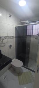 a bathroom with a toilet and a glass shower at Residencial Cidade praiana in Rio das Ostras