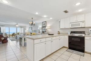 a kitchen with white cabinets and an open floor plan at Short Walk to the Beach Condo in Fernandina Beach