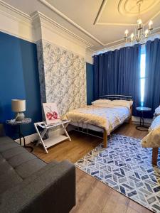 a bedroom with two beds and a couch at Crown Terrace Apartment in London