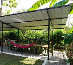een patio met een hangmat en een tafel en stoelen bij Cabaña Campestre Villa Valeria in Yopal