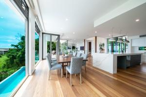 eine offene Küche und ein Esszimmer mit Tisch und Stühlen in der Unterkunft CoralAir Whitsundays in Airlie Beach