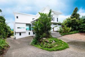 ein weißes Haus mit einem Garten davor in der Unterkunft CoralAir Whitsundays in Airlie Beach