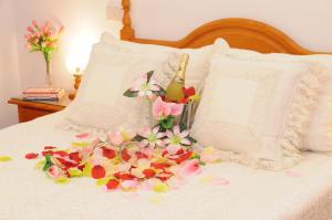 Una cama con un ramo de flores. en EmyCanarias Holiday Homes Vecindario en Vecindario
