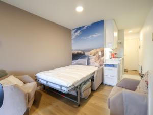 a bedroom with a bed and a painting of a beach at Apartment near Belgian Coast Beach in Oostduinkerke