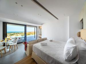 a bedroom with a large bed and a table and chairs at Villa in Gournes with Private Pool & Sea Views in Heraklion +25 photos