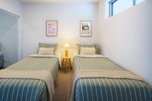 Una cama o camas en una habitación de Azzure Beachside Retreat with Pool Gym and Steam Room