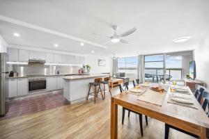 a kitchen and dining room with a table and chairs at Pumicestone Passage Waterfront Escape in Caloundra