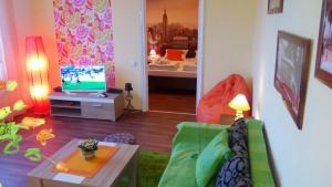 a living room with a green couch and a television at Balkan-inn Skadarlija 2 apartment in Belgrade +6 photos