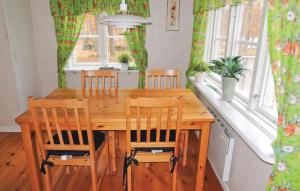 a wooden dining room table with four chairs and a table at Holiday Home Sjöhagen Ljungby in Bolmstad