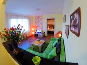 a living room with a green couch and a table at Balkan-inn Skadarlija 2 apartment in Belgrade