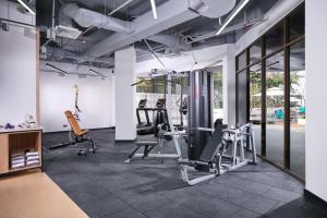 einen Fitnessraum mit Kardiogeräten und Laufbändern in der Unterkunft M Social Resort Penang in George Town