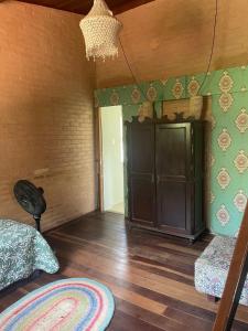 a room with a bed and a cabinet and a rug at Casa maravilhosa Olinda in Olinda
