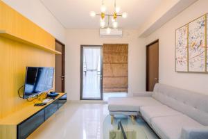 Televiisor ja/või meelelahutuskeskus majutusasutuses Elegant and Comfy 3BR Transpark Cibubur Apartment By Travelio