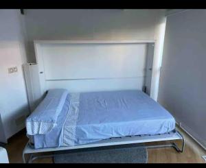 a bed in a room with blue sheets on it at Beautiful apartment Pontevedra in Sanxenxo