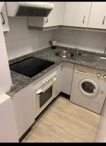 a kitchen with a sink and a washing machine at Beautiful apartment Pontevedra in Sanxenxo