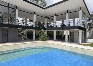 a house with a swimming pool in front of it at Sunny 2-bed condo - fast WIFI in Puntarenas +22 photos
