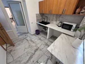 a kitchen with a white counter and a microwave at Ultra Central Piata Libertatii 2 Rooms in Timişoara