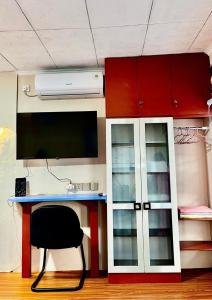 a desk with a monitor and a chair in a room at ZonaBobo Retro Blue Colorful By Belgareti in Cimareme