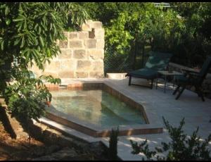 a pool of water with a bench and a table at בקתות באהבה בוטיק in Rosh Pinna +8 photos