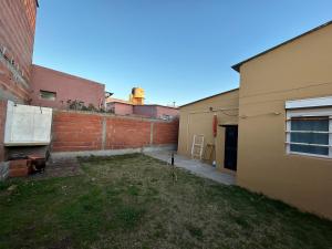 un patio entre dos edificios con una pared de ladrillo en Casa de barrio, en Monte Hermoso