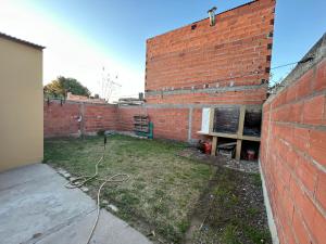 una pared de ladrillo con un patio al lado de un edificio en Casa de barrio, en Monte Hermoso 7 fotos más