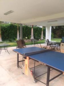 a ping pong table in a pavilion with tables and chairs at FABULOSO HOTEL CON 2 MAGNIFICAS ALBERCAS, a MINUTOS DE CUERNAVACA in Jiutepec