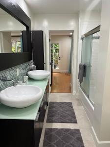 a bathroom with two sinks and a walk in shower at Stunning, Quiet Vista Retreat Minutes from Beach in Vista
